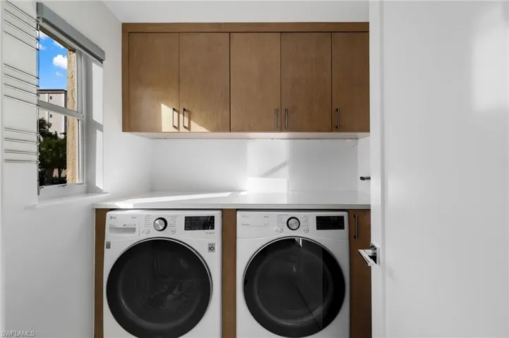 Laundry area featuring washing machine and dryer and cabinet space