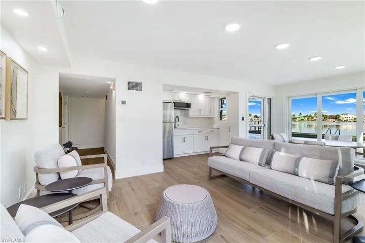 Living room with light wood finished floors, recessed lighting, and a water view