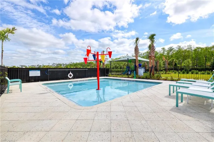 Pool with fence, a patio area, and playground community