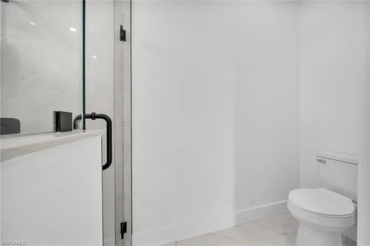 Bathroom featuring a shower stall and toilet