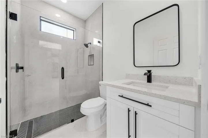 Full bath featuring vanity and a marble finish shower