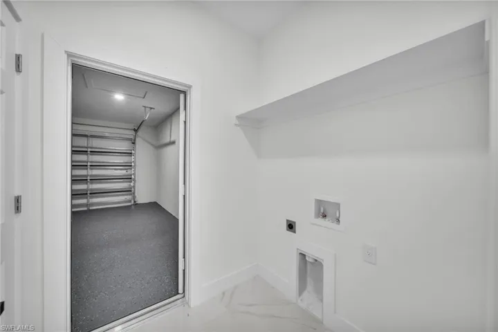 Laundry area featuring hookup for an electric dryer, washer hookup, and light marble finish flooring