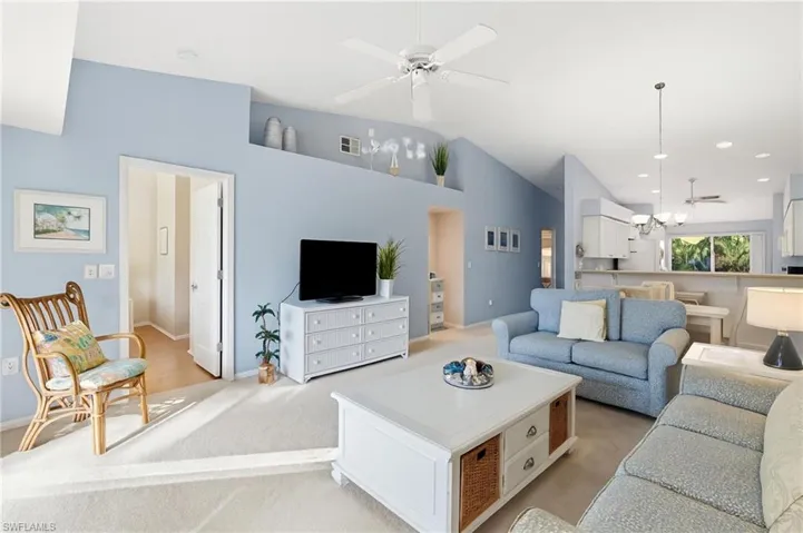 Carpeted living room featuring a ceiling fan, recessed lighting, and high vaulted ceiling