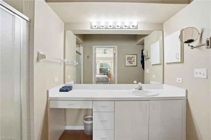 Ensuite bathroom with vanity, a shower stall, and ceiling fan