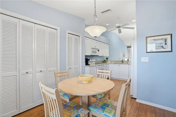 Dining space featuring a ceiling fan, light wood finished floors, vaulted ceiling, and recessed lighting