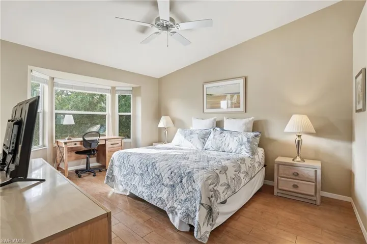 Bedroom featuring vaulted ceiling, a desk, ceiling fan, and light wood-style floors