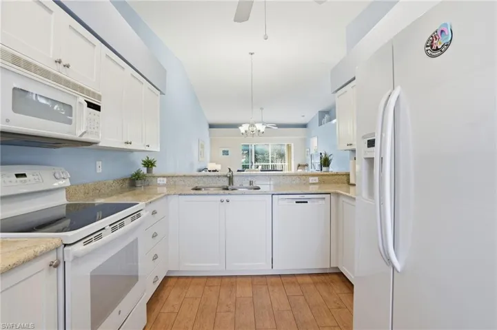 Kitchen with white appliances and white cabinetry