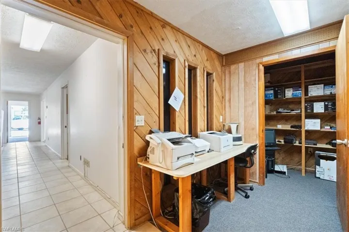Office area with a textured ceiling and wooden walls