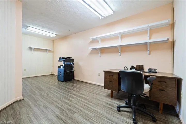 Office space with light wood-type flooring and a textured ceiling