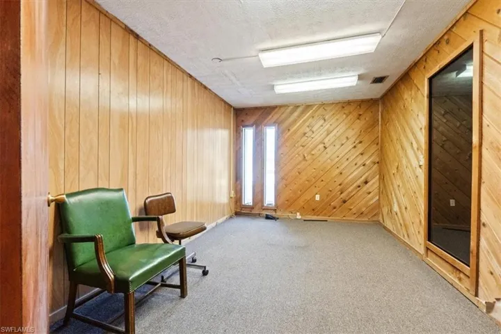 Sitting room with a textured ceiling and wood walls