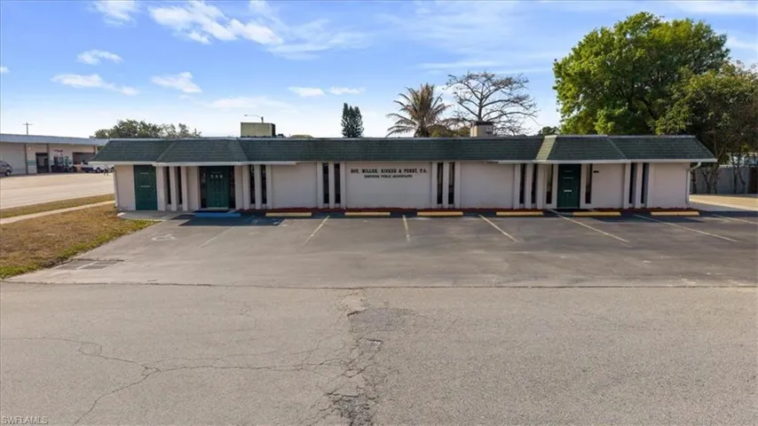 View of building exterior with uncovered parking