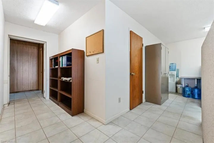 Hall featuring light tile patterned floors and a textured ceiling