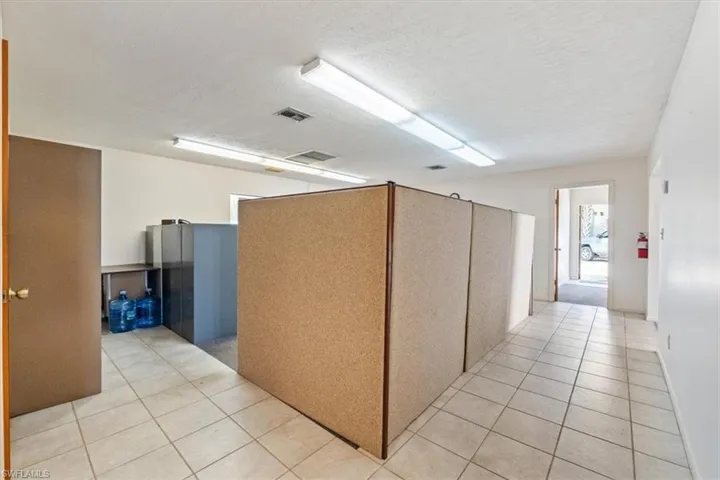 Hall featuring a textured ceiling and light tile patterned floors