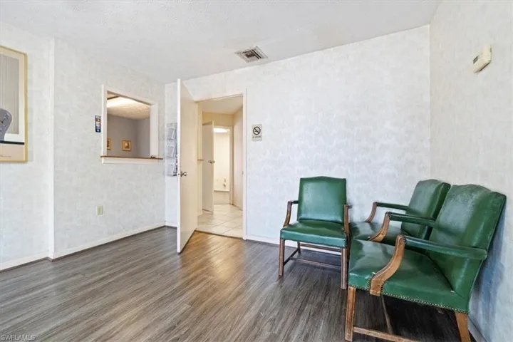 Living area featuring a textured ceiling and wallpapered walls
