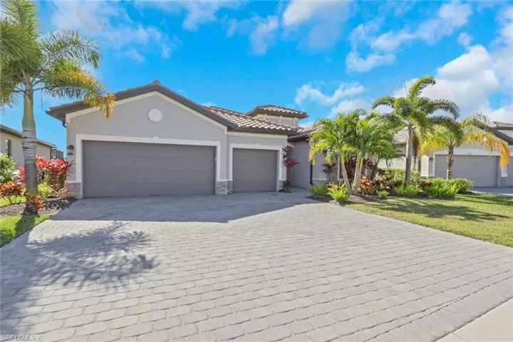 Mediterranean / spanish-style house with stone siding, stucco siding, decorative driveway, and an attached garage