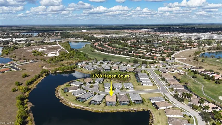 Aerial view of property's location featuring a nearby body of water, nearby suburban area, and a golf club