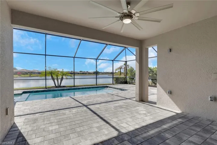 Outdoor pool featuring a patio area, a sunroom, a lanai, and a water view