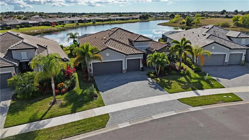 View of front of property with a water view, decorative driveway, stucco siding, an attached garage, and a tiled roof