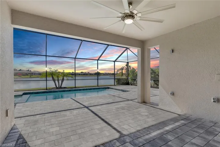 Outdoor pool featuring a sunroom, a patio, and a lanai
