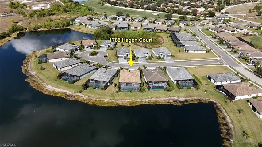 Aerial view of property and surrounding area with a large body of water and nearby suburban area