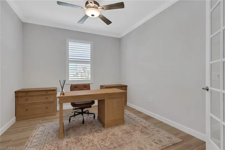 Office area featuring crown molding, light wood-style flooring, and ceiling fan