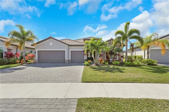 View of front of house with a front lawn, stone siding, a garage, stucco siding, and decorative driveway