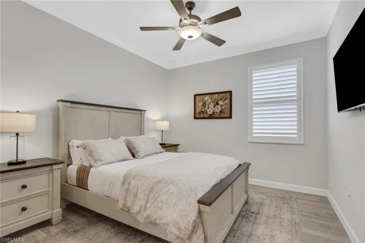 Bedroom with ornamental molding, wood finish floors, and ceiling fan