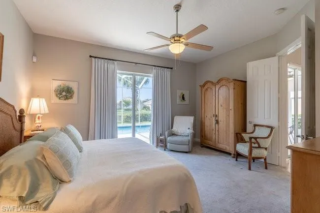 Bedroom featuring light carpet, ceiling fan, and access to outside