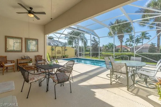 View of pool with a lanai, ceiling fan, and a patio area
