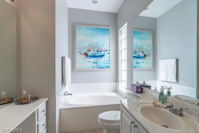 Bathroom with a bathtub, vanity, and toilet