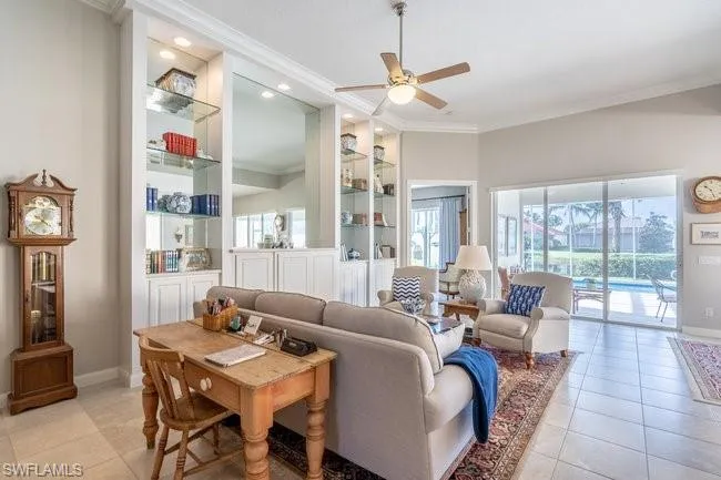 Tiled living room featuring crown molding and ceiling fan