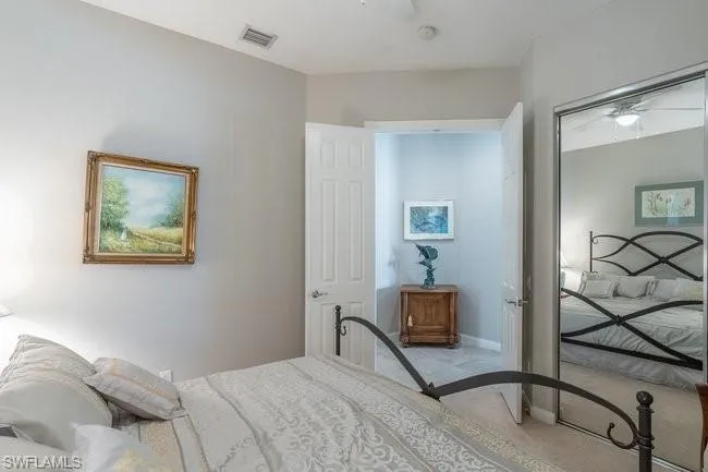 Bedroom with light colored carpet and a closet