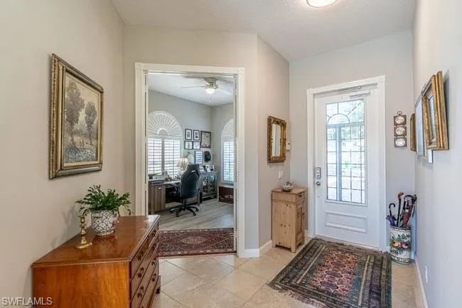 Tiled entryway featuring ceiling fan