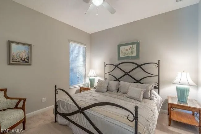 Carpeted bedroom featuring lofted ceiling and ceiling fan