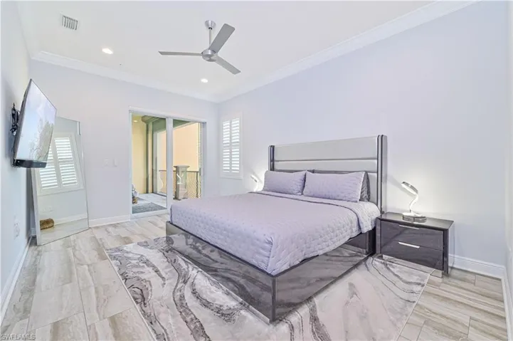 Bedroom featuring ceiling fan, multiple windows, and crown molding