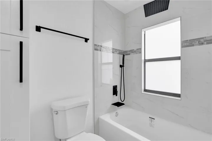 Full bathroom with shower / bath combination and toilet
