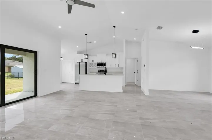 Unfurnished living room featuring high vaulted ceiling, ceiling fan, and recessed lighting