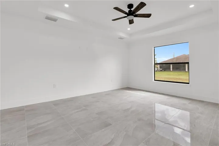 Spare room with a tray ceiling, recessed lighting, and ceiling fan