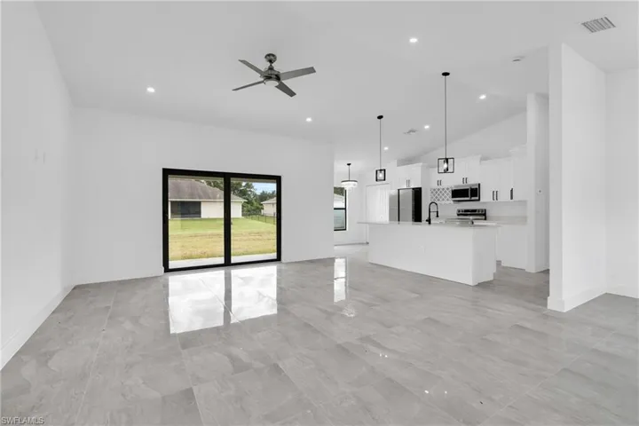 Unfurnished living room featuring ceiling fan, recessed lighting, and high vaulted ceiling