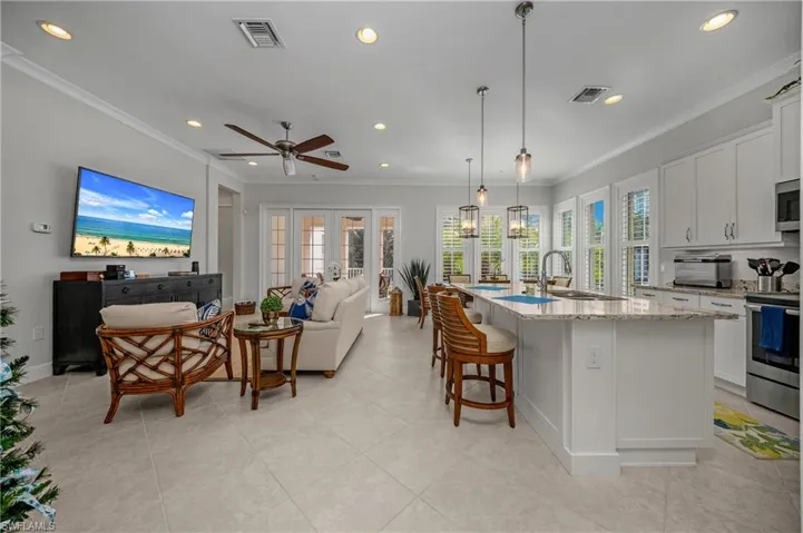 Kitchen with open floor plan, white cabinetry, a breakfast bar, recessed lighting, and appliances with stainless steel finishes