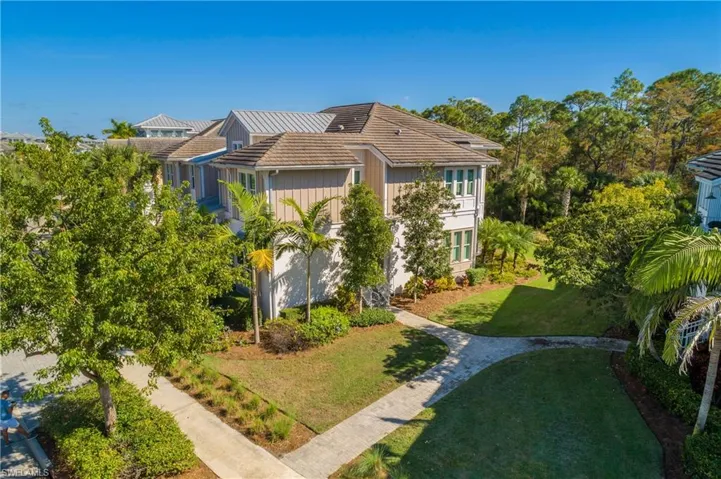 View of property exterior with a tile roof and a yard