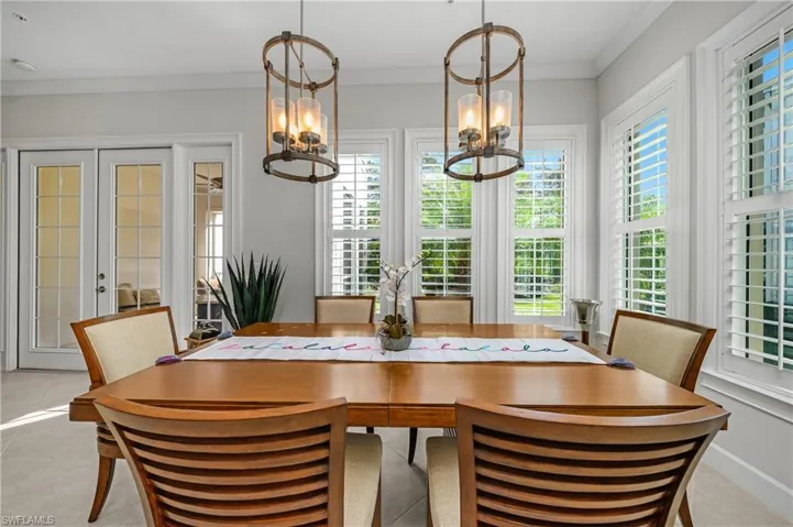 Dining area featuring crown molding, french doors, plenty of natural light, and light tile patterned floors
