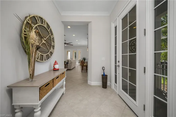 Hallway with crown molding, recessed lighting, and light tile patterned floors
