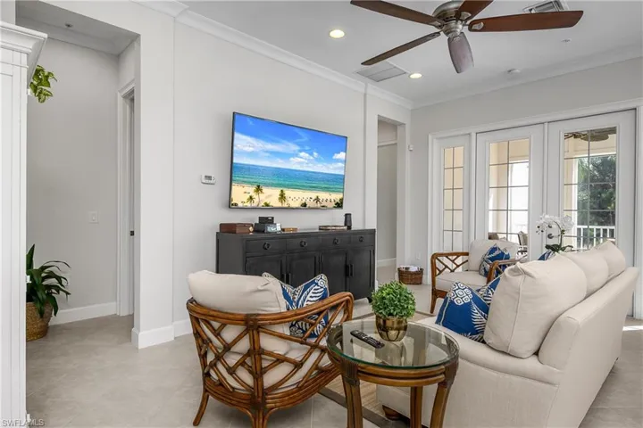 Living area featuring ornamental molding, recessed lighting, a ceiling fan, and french doors