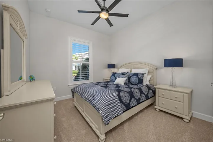 2nd Bedroom with light colored carpet and ceiling fan