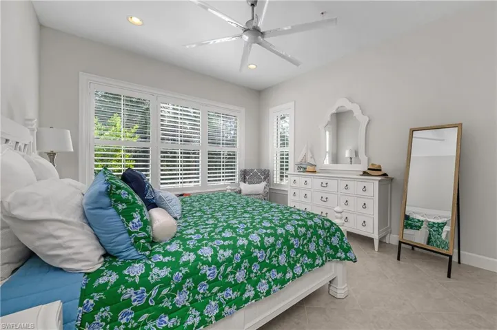 Bedroom featuring multiple windows, light tile patterned floors, ceiling fan, and recessed lighting
