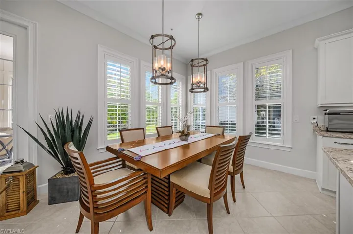 Dining area featuring crown molding, a chandelier, and light tile patterned flooring