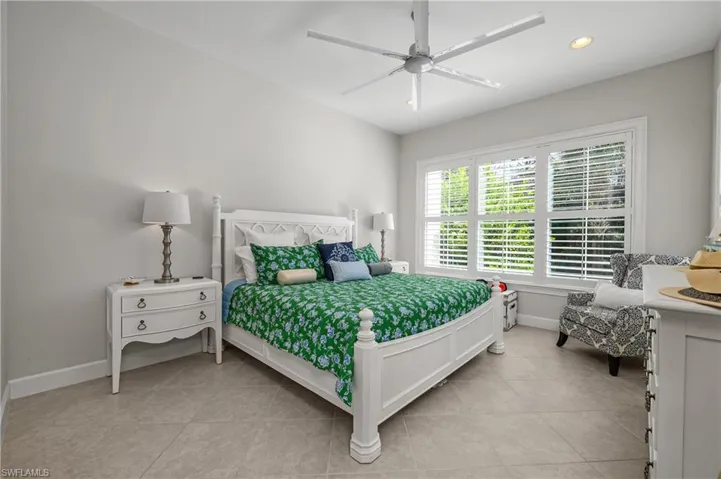 Bedroom with light tile patterned floors, ceiling fan, and recessed lighting