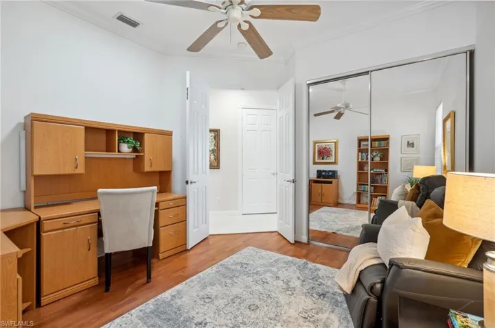 Home office featuring ceiling fan, light wood-type flooring, and ornamental molding