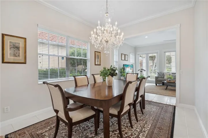 Dining space featuring crown molding, light tile patterned floors, and an inviting chandelier